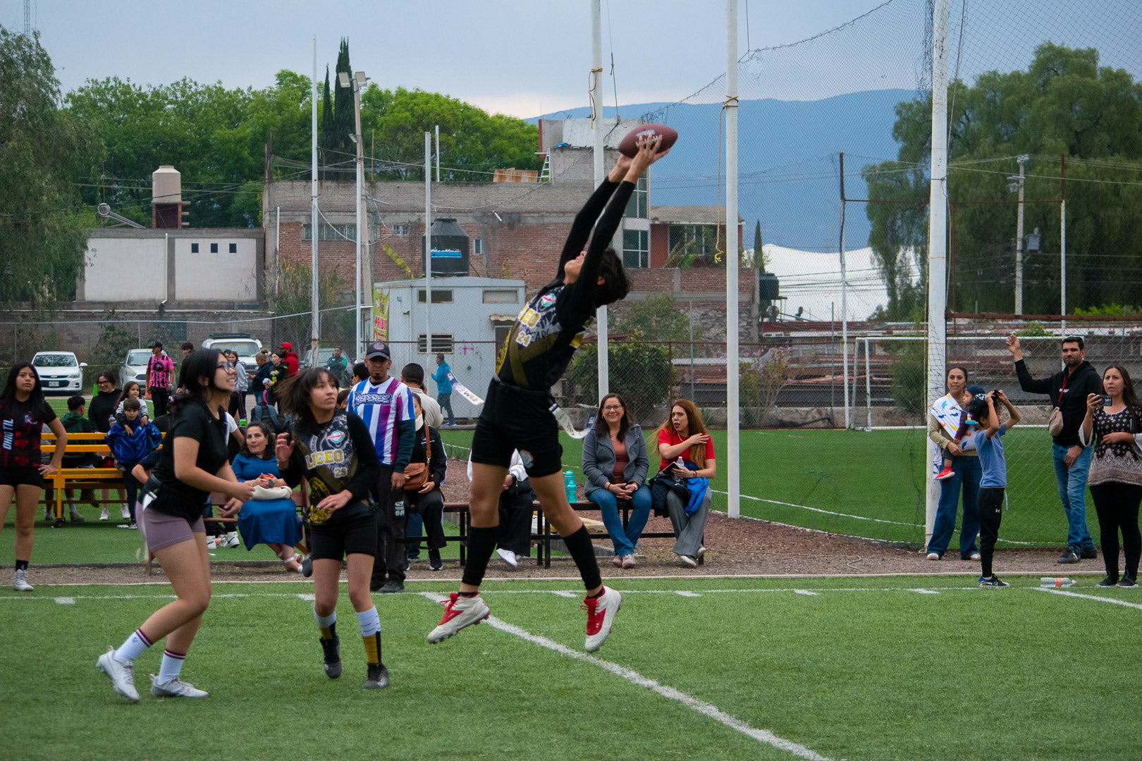 Jugadora de futbol bandera atrapando el balón en salto